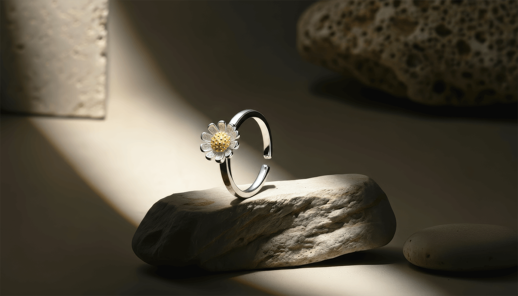 Silver ring with a floral design on a stone surface